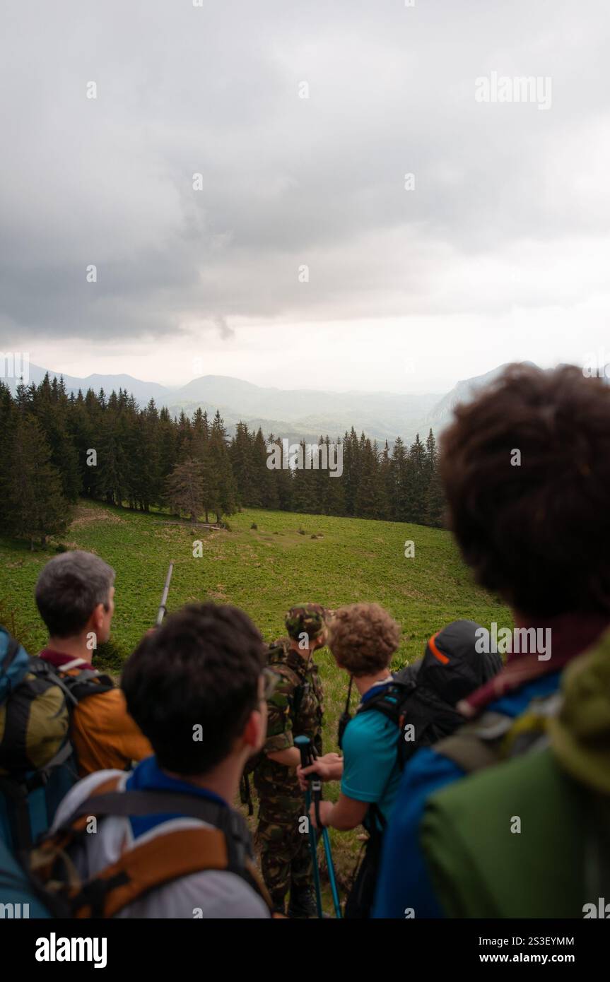 Eine Gruppe von Menschen, die an einem sonnigen Tag eine atemberaubende Berglandschaft bewundern. Die ruhige Aussicht fängt die Schönheit der Natur und die Erkundung der Natur ein. Stockfoto