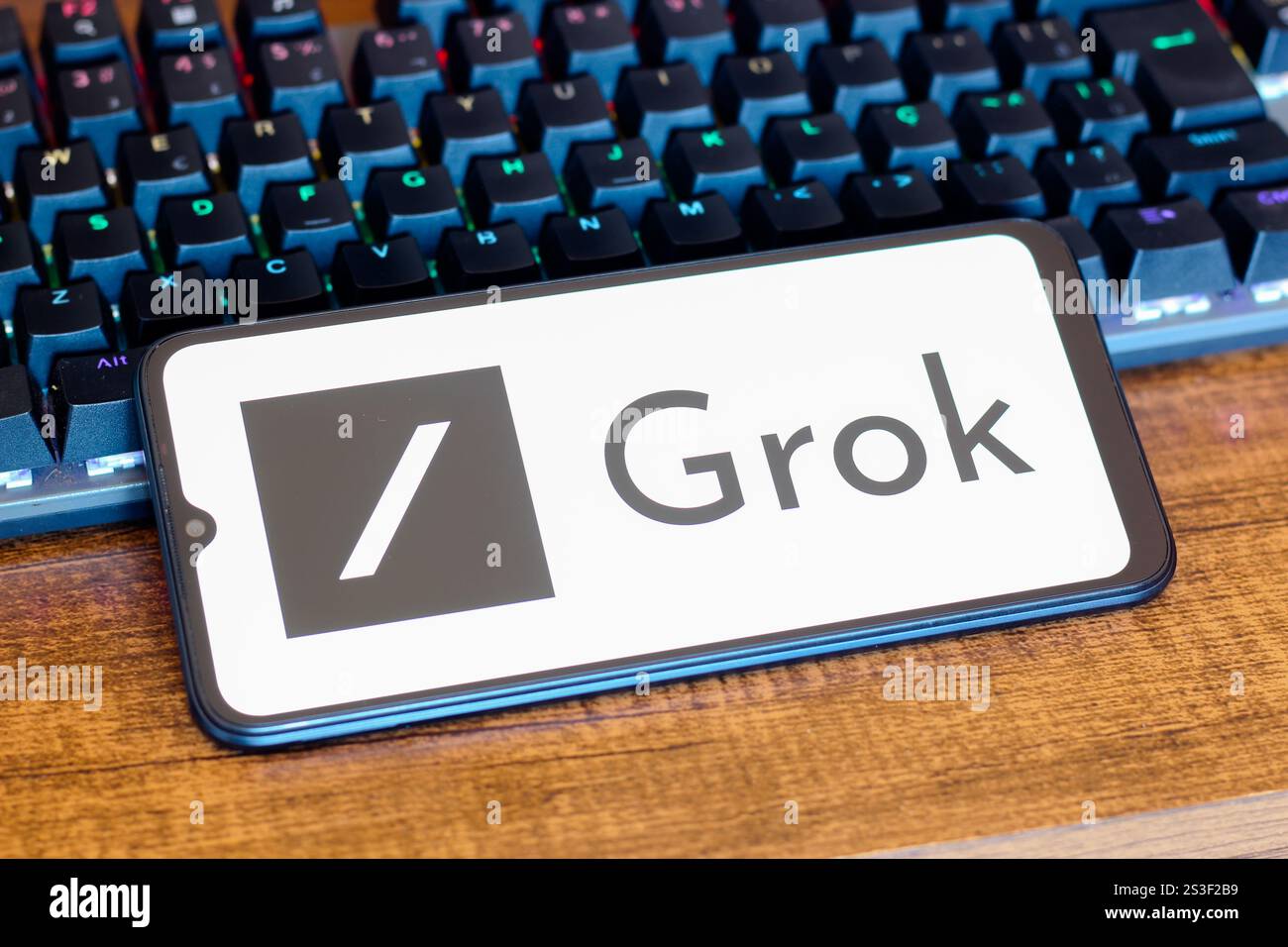 In dieser Abbildung wird das Grok-Logo auf einem Smartphone-Bildschirm neben einer Tastatur angezeigt. Stockfoto