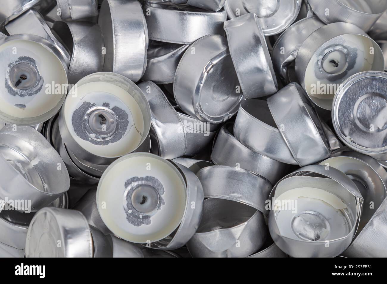 Viele leere Aluminiumbecher aus verbrannten Teelichtern. Hintergrund, Nahaufnahme. Stockfoto