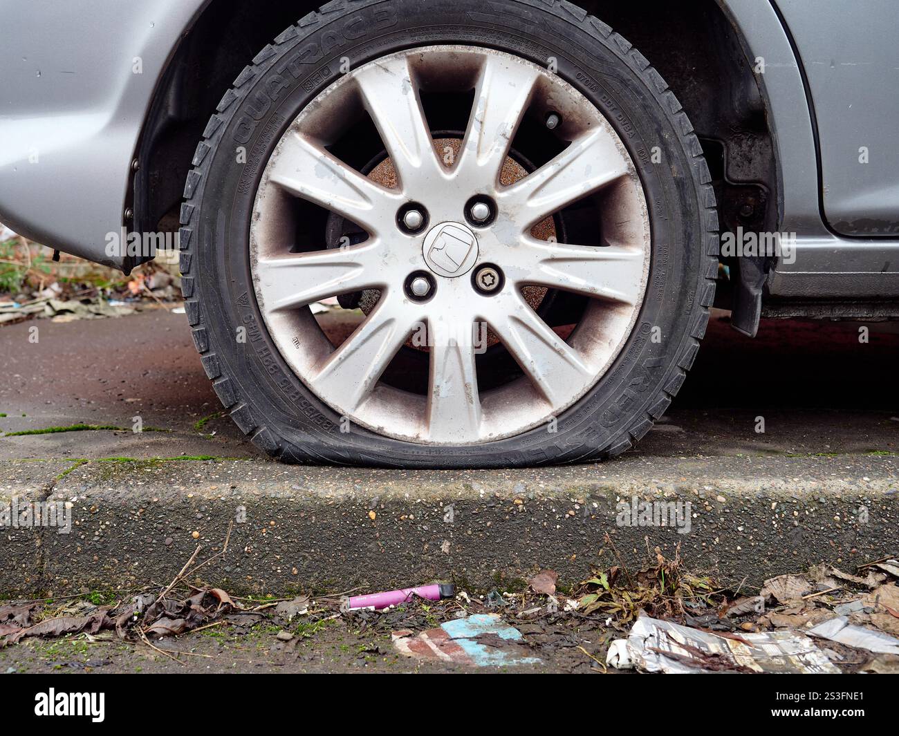 Salford, Manchester, Großbritannien, 01-04-2025: Reifenpannen auf einem Auto, das auf einem übersäten Straßenrand geparkt ist. Stockfoto