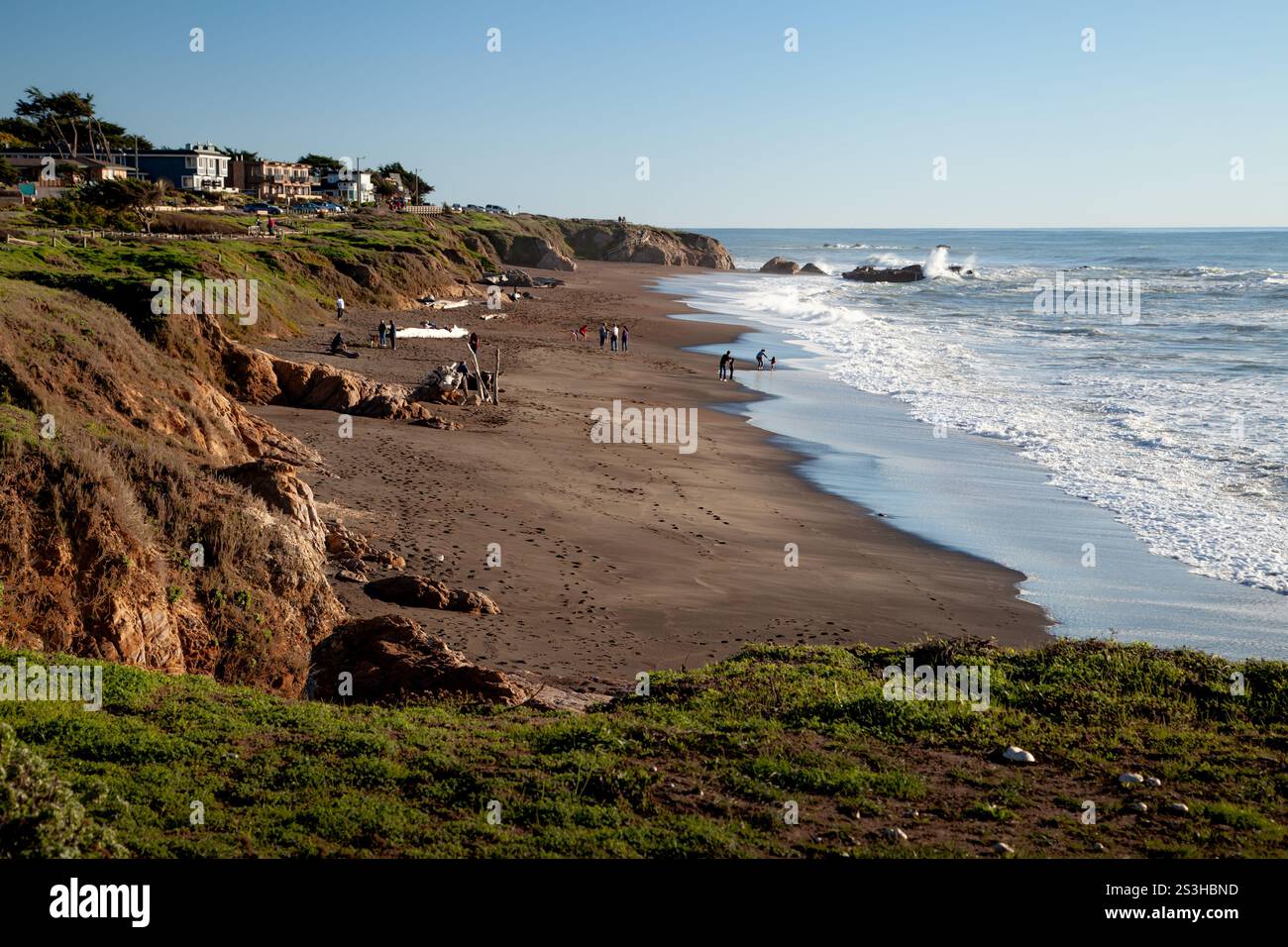 Moonstone Beach in Kalifornien an einem sonnigen Dezembertag mit Wellen, die sanft auf den Sandstrand neben dem Pazifik stürzen. Stockfoto