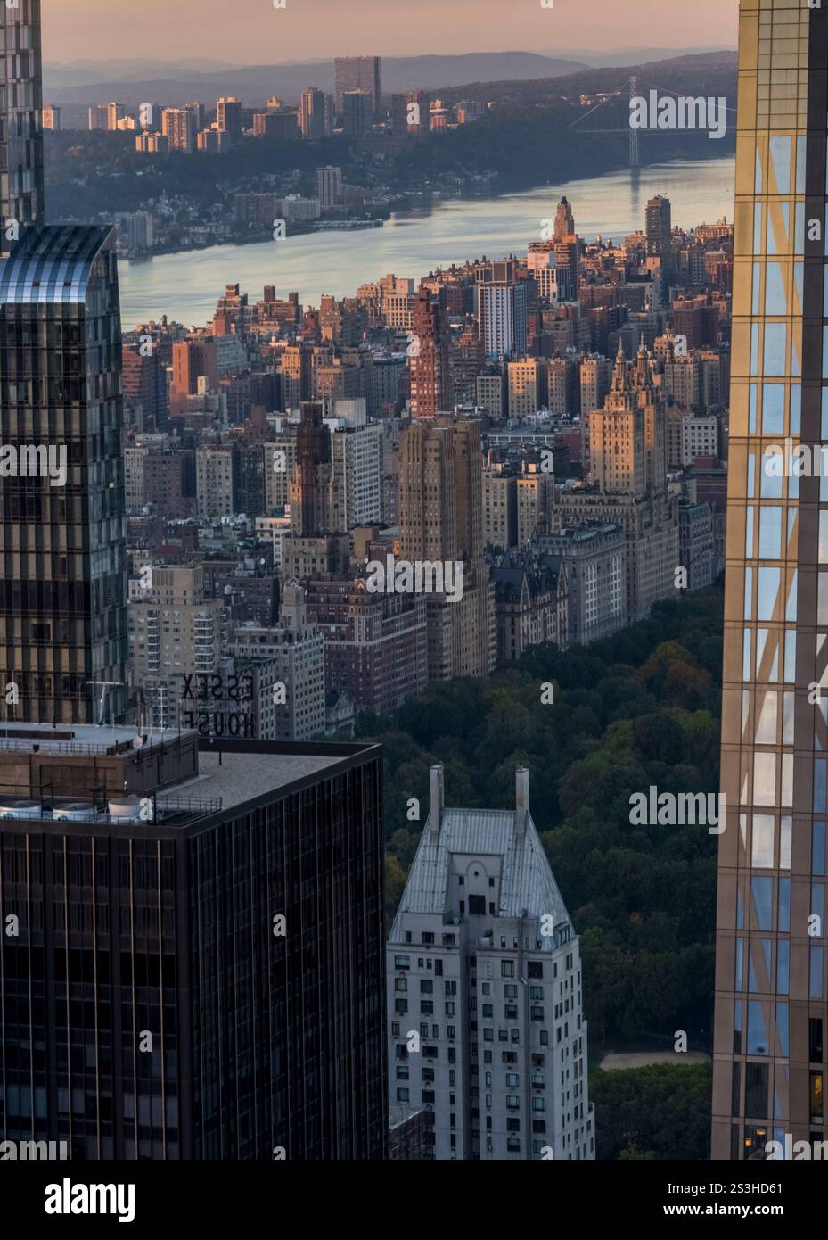 Atemberaubende Aussicht vom Top of the Rock: Upper West Side, George Washington Bridge, Central Park's Green und der Hudson River, der im goldenen Licht leuchtet. Stockfoto