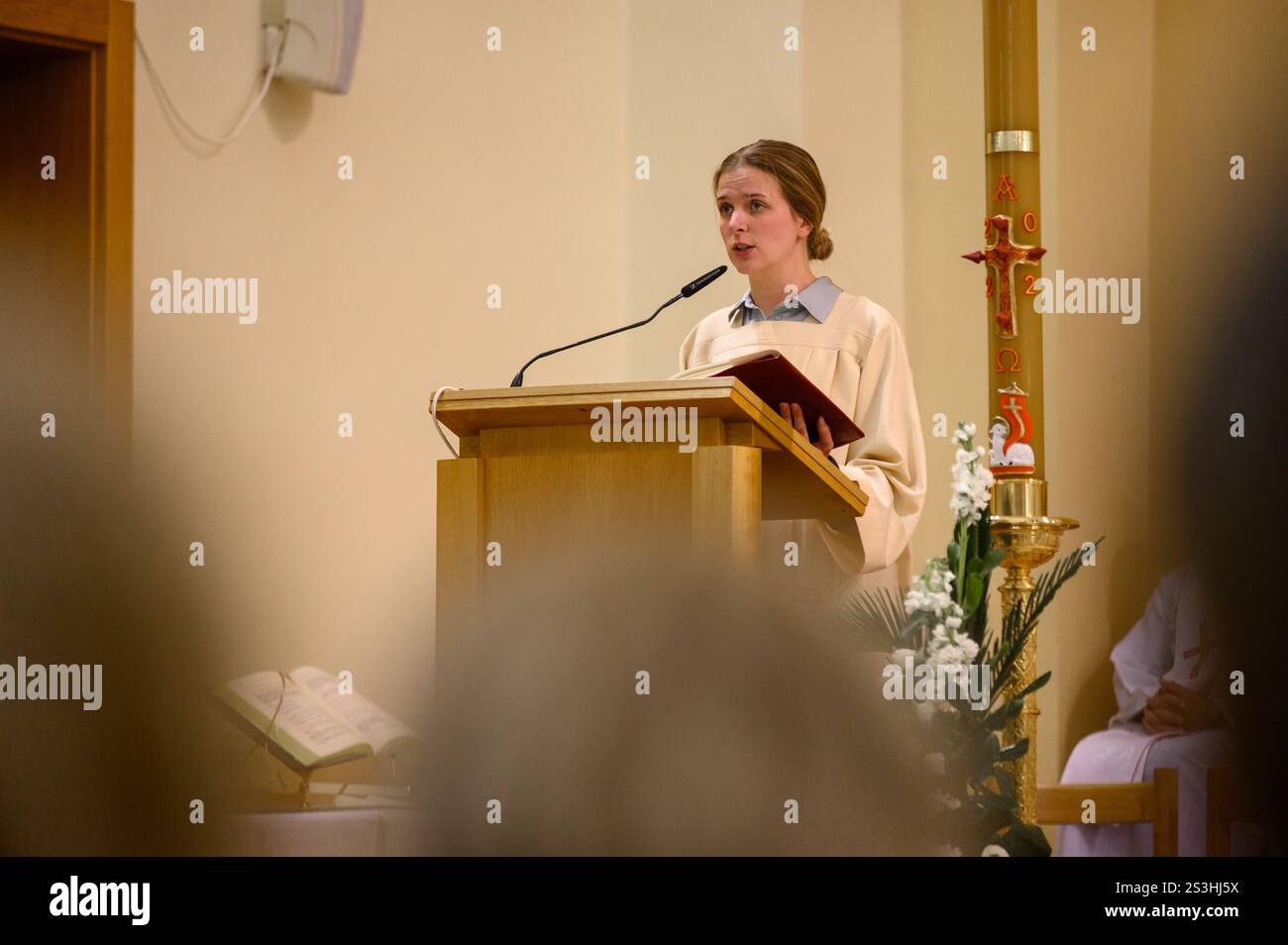 Eine junge Frau, die während der Heiligen Messe am Ostervigil in der St.-Jakobskirche in Medjugorje die Schrift las. Stockfoto