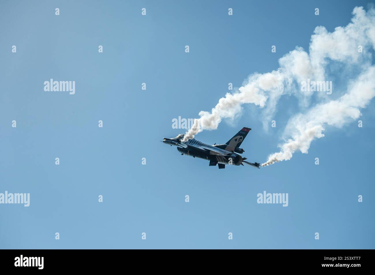 Jet-Flugzeug fliegt hoch am Himmel und hinterlässt eine Rauchspur hinter sich. Stockfoto