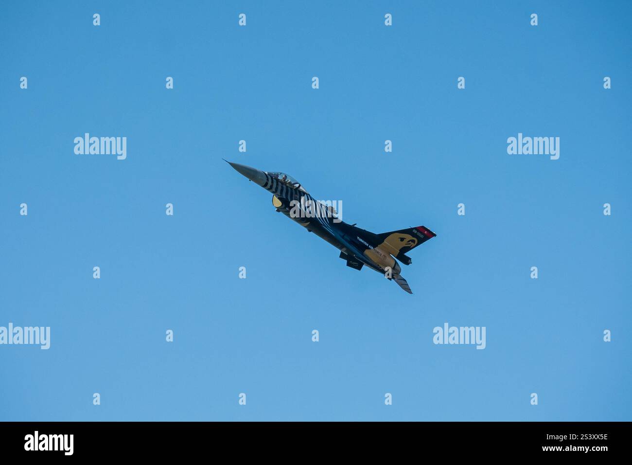 Die türkische Luftwaffe F-16 Kampfflugzeug im Flug, seine schlanke Silhouette schneidet sich durch die Weite des Himmels. Stockfoto