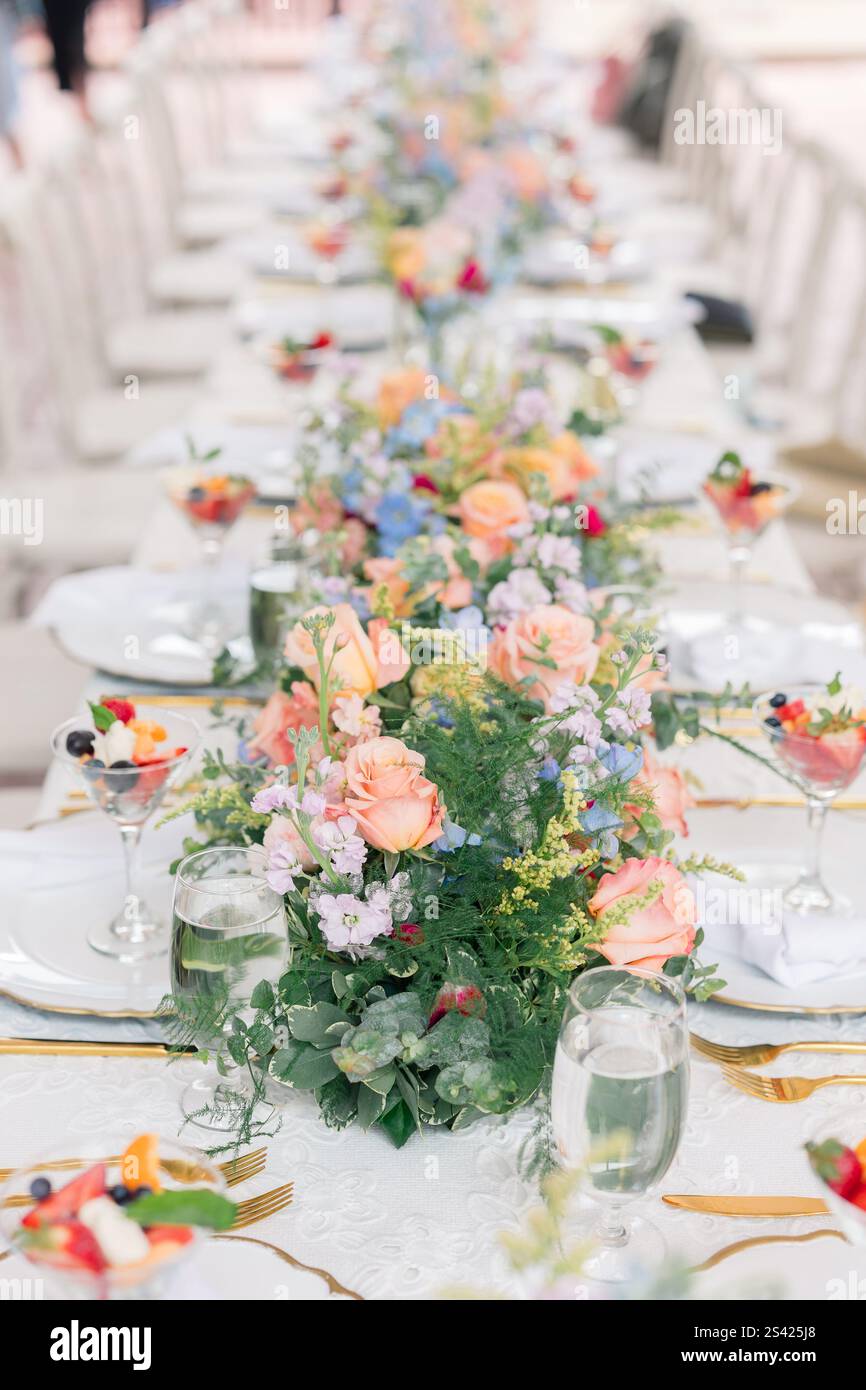 Herzstück des Tischs mit Blumenmuster und pfirsichfarbenen Rosen bei einem eleganten Brunch. Stockfoto