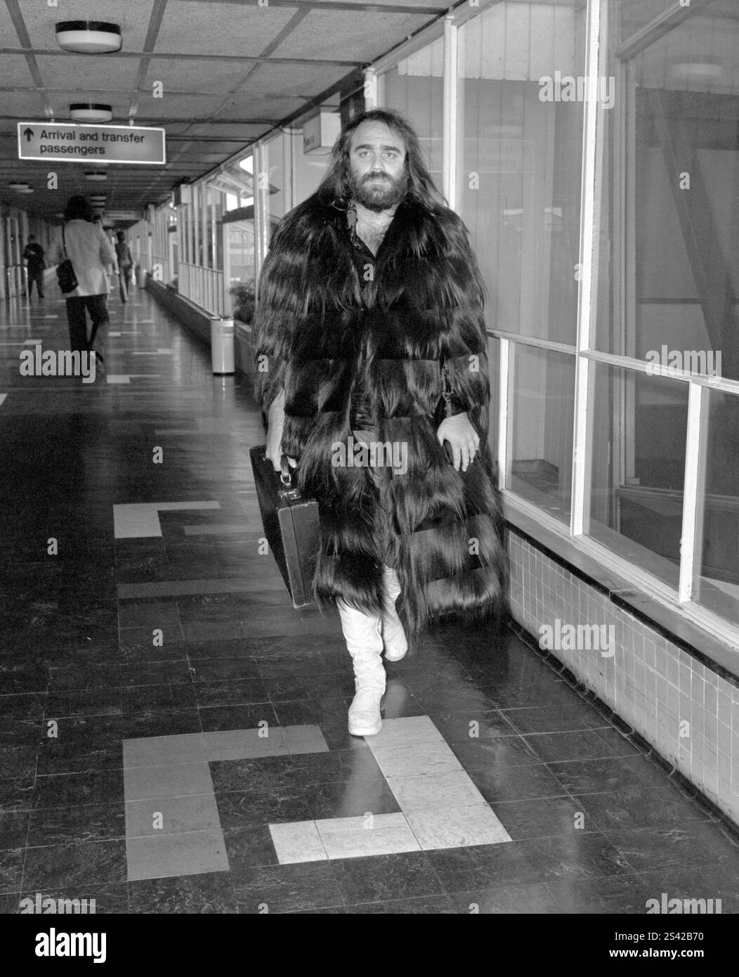 Dateifoto vom 04/74 des griechischen Sängers Demis Roussos verlässt den Londoner Flughafen Heathrow. Die Verräterin Claudia Winkleman sagte, ihr Stil sei von Schauspielerin Anita Dobson und der griechischen Sängerin Demis Roussos beeinflusst. Sie sagte, dass ihre Outfits auf Strictly Come Dancing von ihnen beeinflusst wurden und ihr Stil für die BBC Reality Gameshow eine Mischung aus Princess Royal und Sängerin Sarah Brightman war. Ausgabedatum: Freitag, 10. Januar 2025. Stockfoto