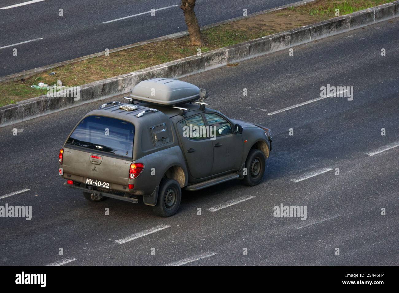 Dunkelgrauer mitsubishi l200 triton Pickup-Lkw, der auf Asphaltstraßen mit Dachkasten fährt Stockfoto