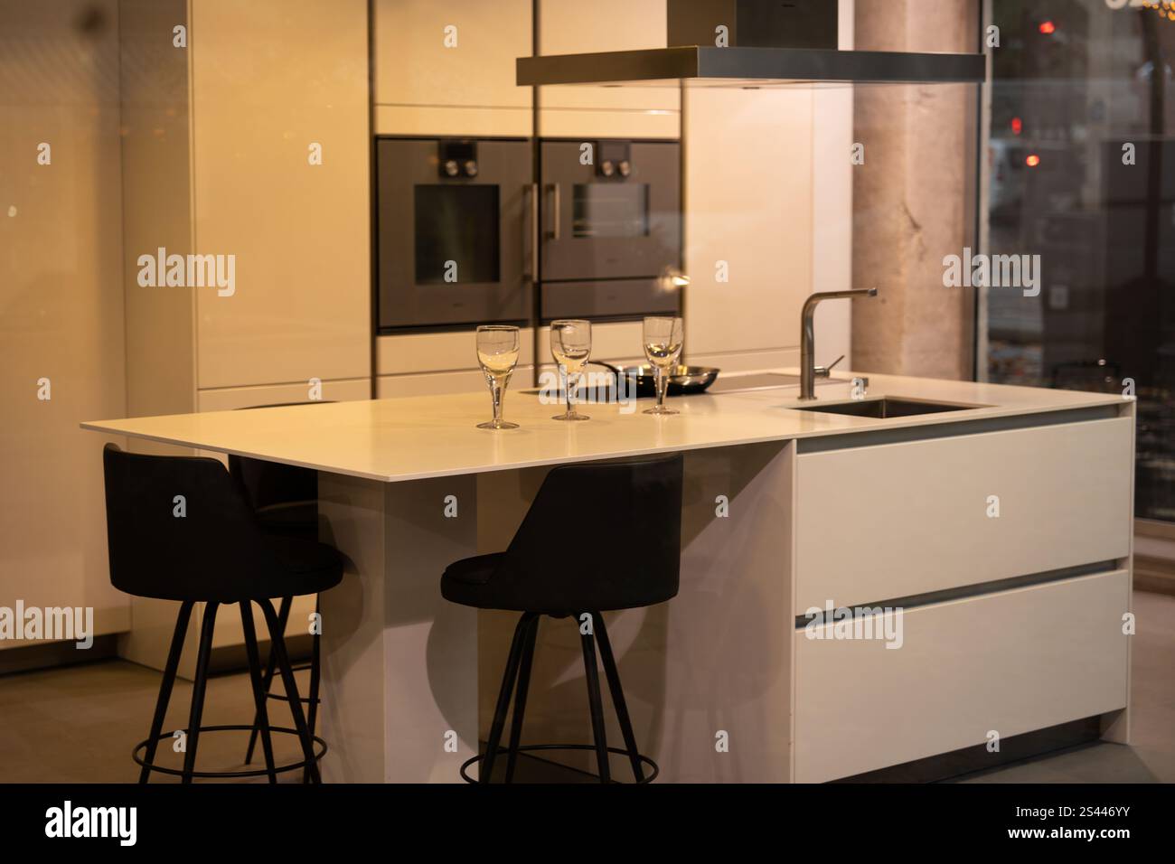 Moderne Küche mit eleganter Arbeitsplatte und stilvollen Barhockern Stockfoto