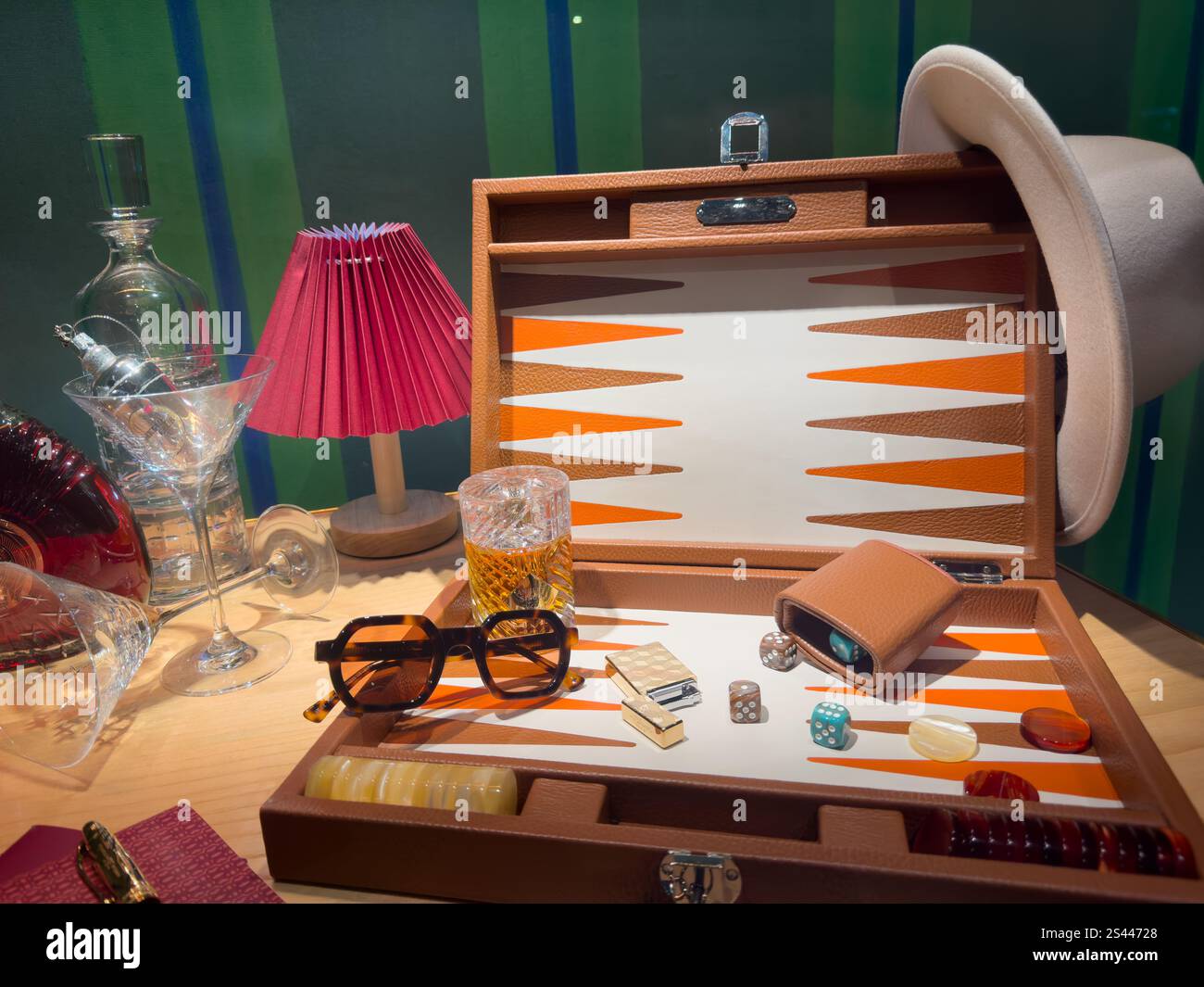 Vintage-Spielset mit eleganten Accessoires wie Gläsern, einer Lampe und einem Cocktailglas auf einem Holztisch Stockfoto