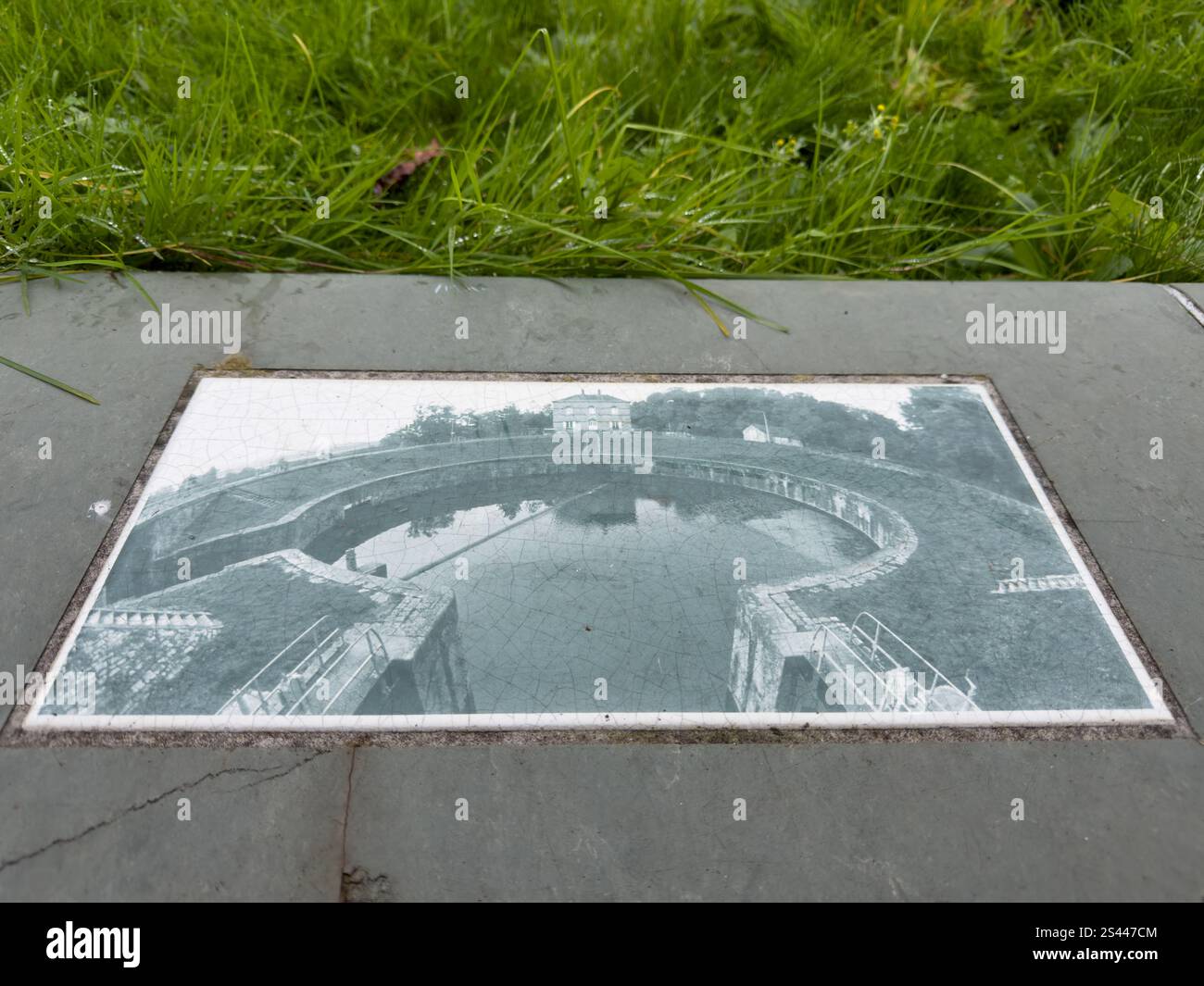 Eine historische Darstellung einer runden Brücke über ruhiges Wasser, umgeben von üppigem Grün in einem Outdoor Park an einem bewölkten Tag Stockfoto