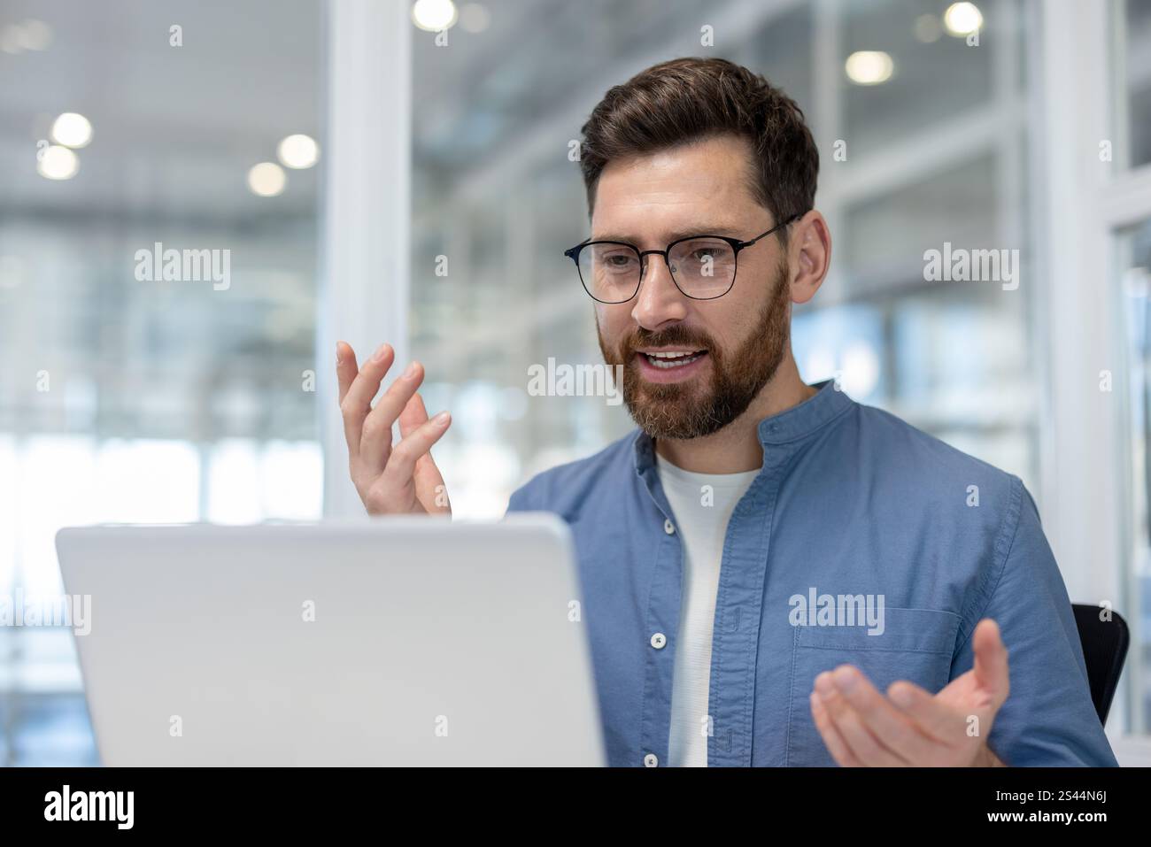 Videoanrufe, Mann im Büro, der mit Kollegen und Partnern spricht, Mitarbeiter, die ein Notebook für Online-Videokonferenzen und Online-Geschäftstreffen verwenden. Stockfoto