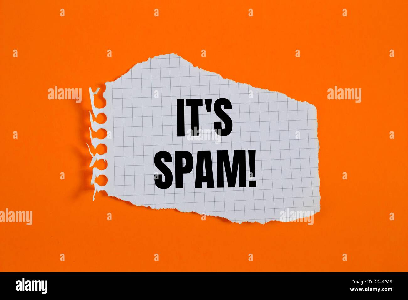 Es ist eine Spam-Nachricht, geschrieben auf gerissenem, kariertem Papier mit orangem Hintergrund. Konzeptionell ist das Spam-Symbol. Kopierbereich. Stockfoto