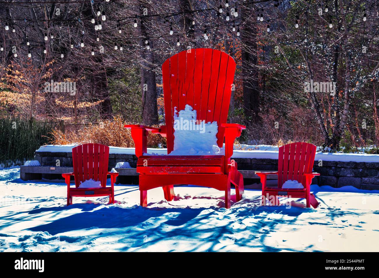 Ein großer und zwei kleine rote Stühle im Schnee Stockfoto