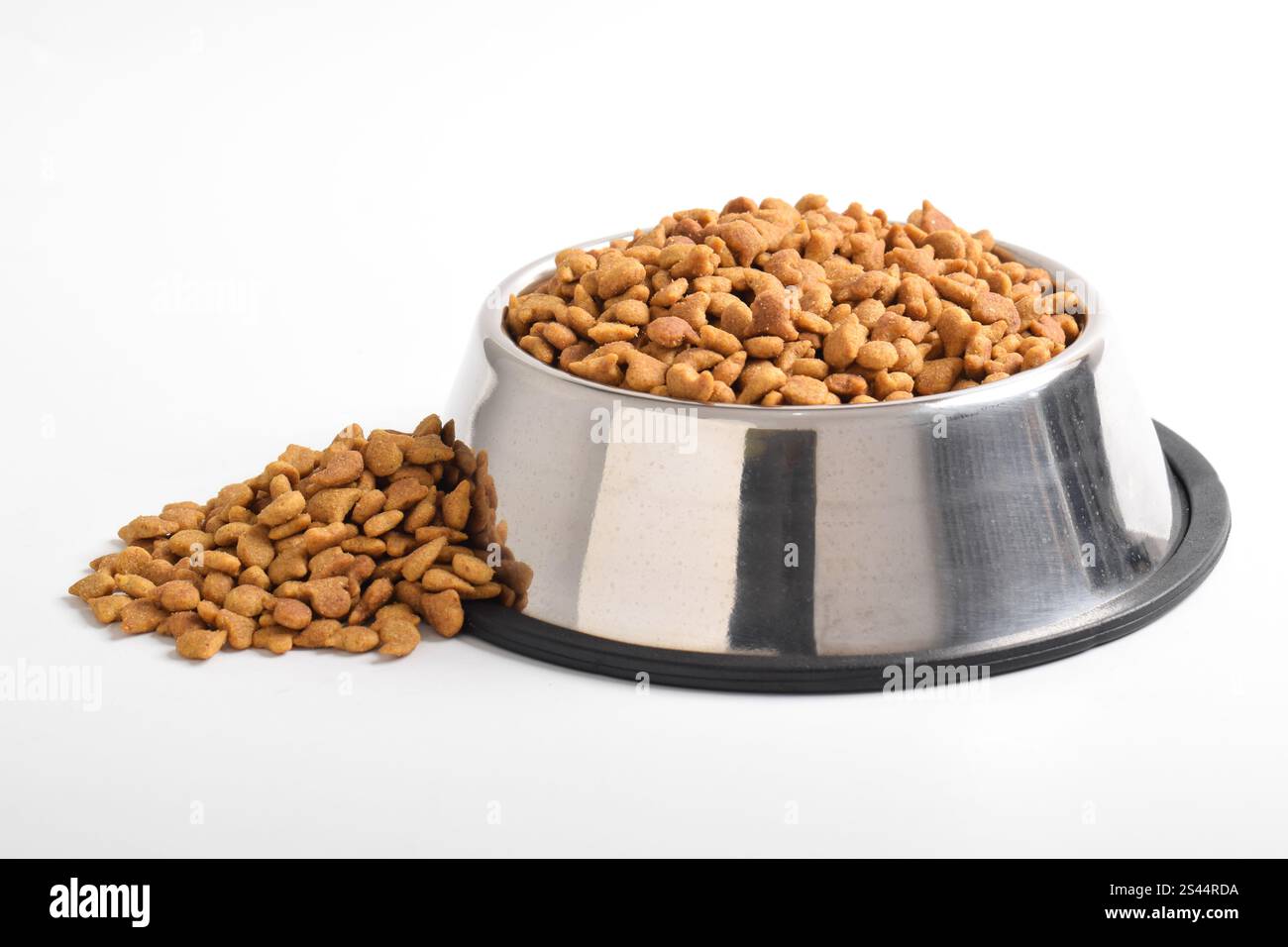 Trockenfutter für Katzen in Schüssel isoliert auf weißem Hintergrund. Braunes Katzenfutter Stockfoto