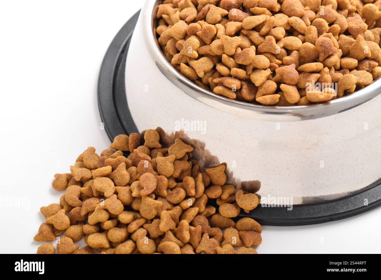 Trockenfutter für Katzen in Schüssel isoliert auf weißem Hintergrund. Braunes Katzenfutter Stockfoto