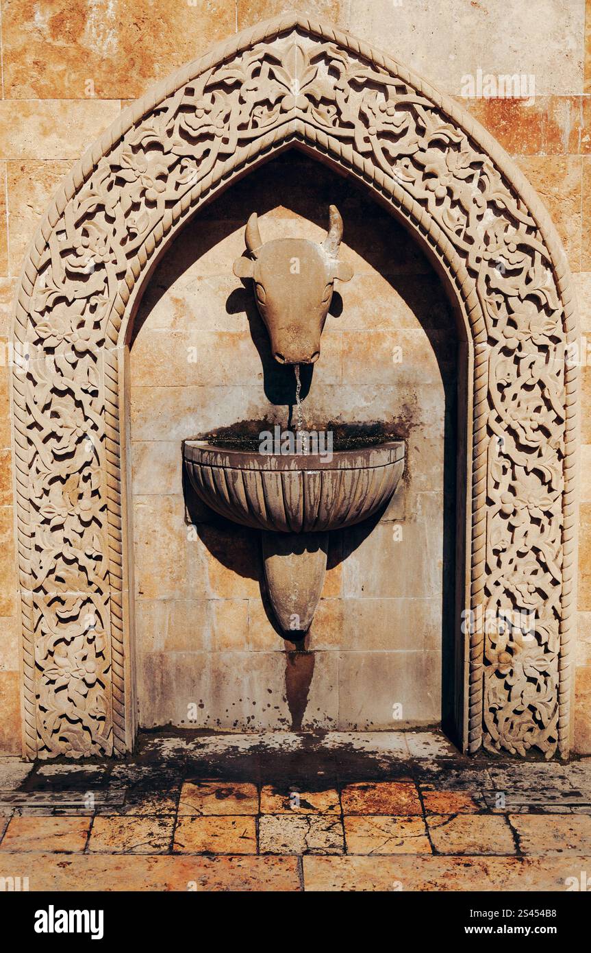 Trinkbrunnen aus Stein in Form eines Stierkopfes im alten Teil der Stadt Stockfoto
