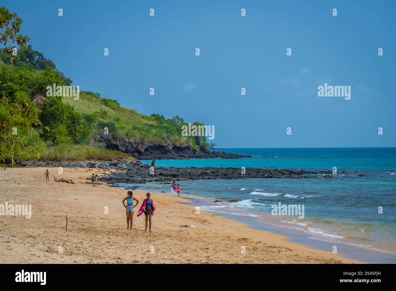 Leute, die an einem Strand in Sao Tome und Principe spazieren gehen. Stockfoto