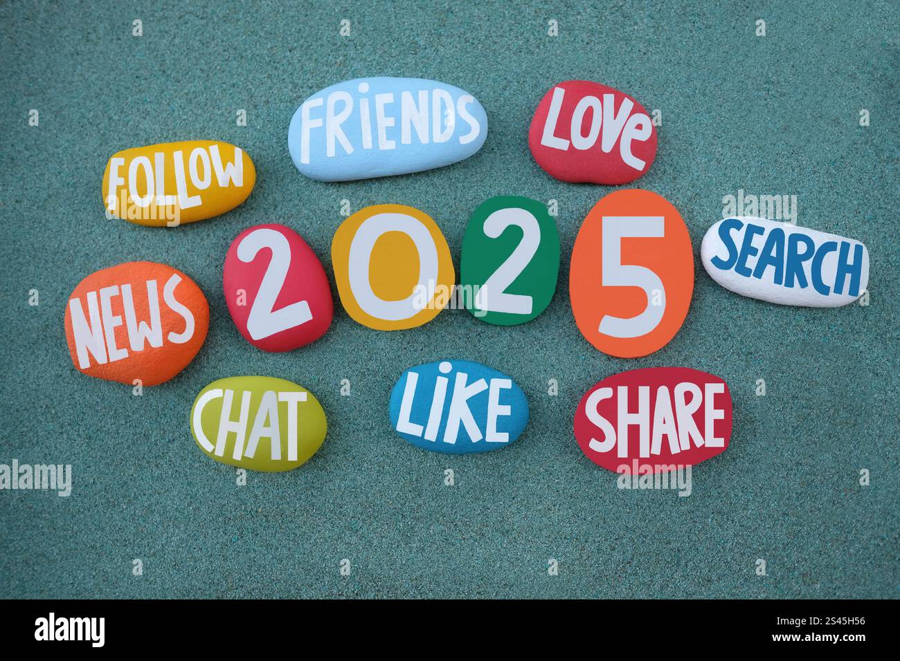 Happy 2025 voller Freude, Leben, Chat, Follower, Freunde, liebe, suche, Nachrichten und Teile kreative, mehrfarbige, handgemalte Steine auf grünem Sand Stockfoto