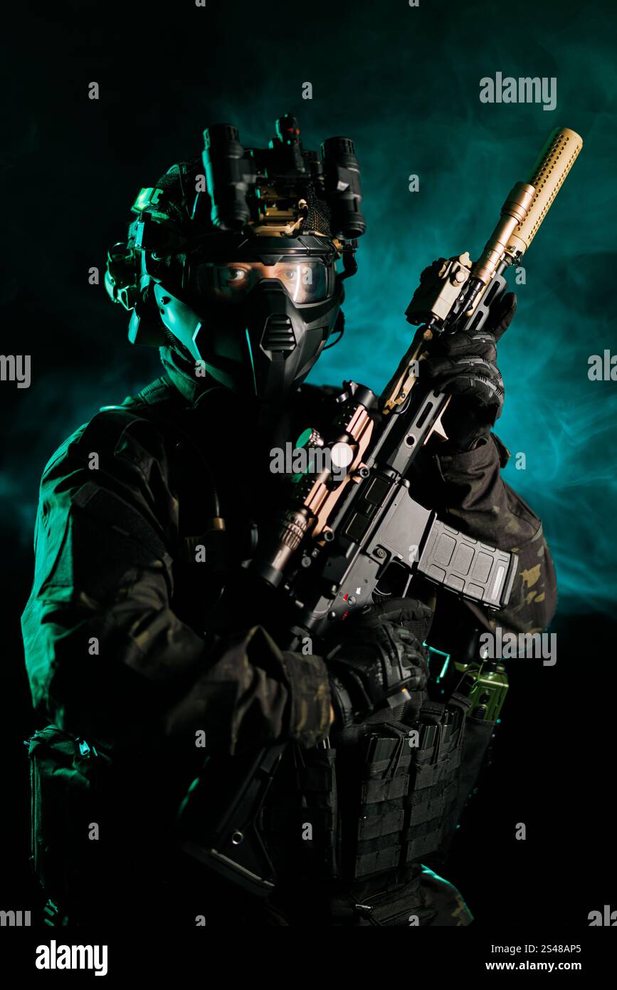 Ein Soldat, der fortschrittliche taktische Ausrüstung und Nachtsichtgeräte trägt, ein Gewehr vor einem dramatischen grünen Rauch hält, verkörpert Autorität, Re Stockfoto