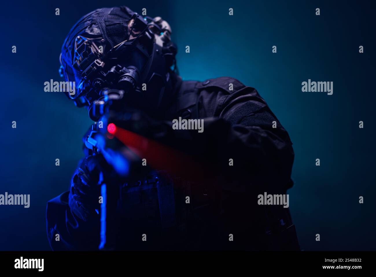 Soldat der Spezialkräfte in taktischer Ausrüstung mit einer Waffe, die mit einem roten Laser zielt. In einem dynamischen und intensiven Setup, das die Leistungsfähigkeit unterstreicht Stockfoto