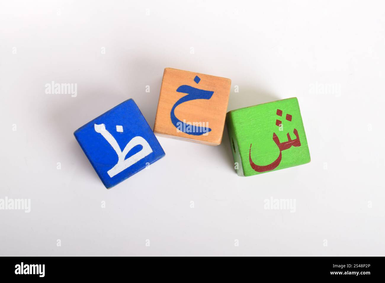 Holzblöcke mit arabischem Alphabet isoliert auf weißem Hintergrund. Kindergartenbildungskonzept. Flache Lagen Stockfoto