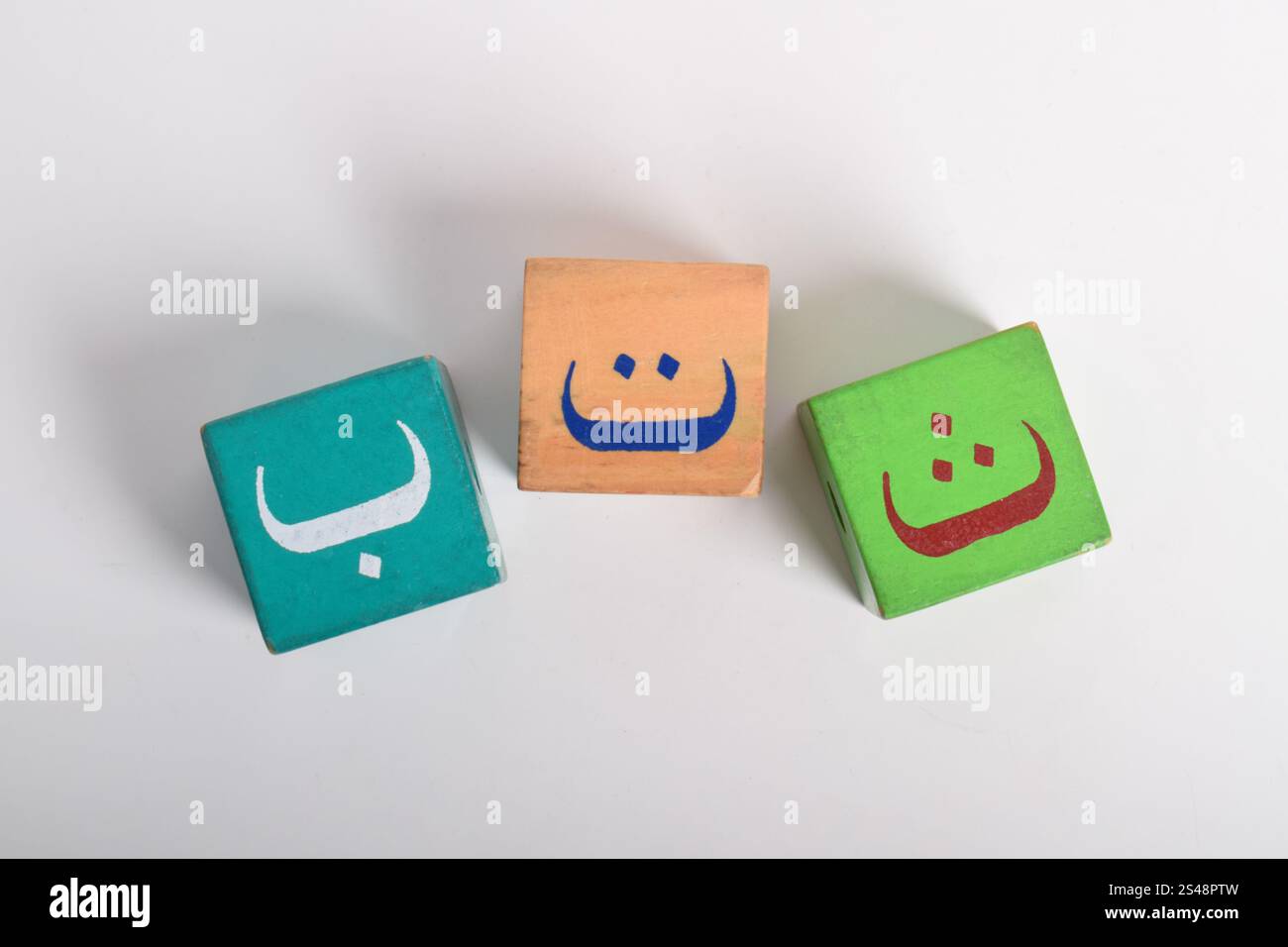 Holzblöcke mit arabischem Alphabet isoliert auf weißem Hintergrund. Kindergartenbildungskonzept. Flache Lagen Stockfoto