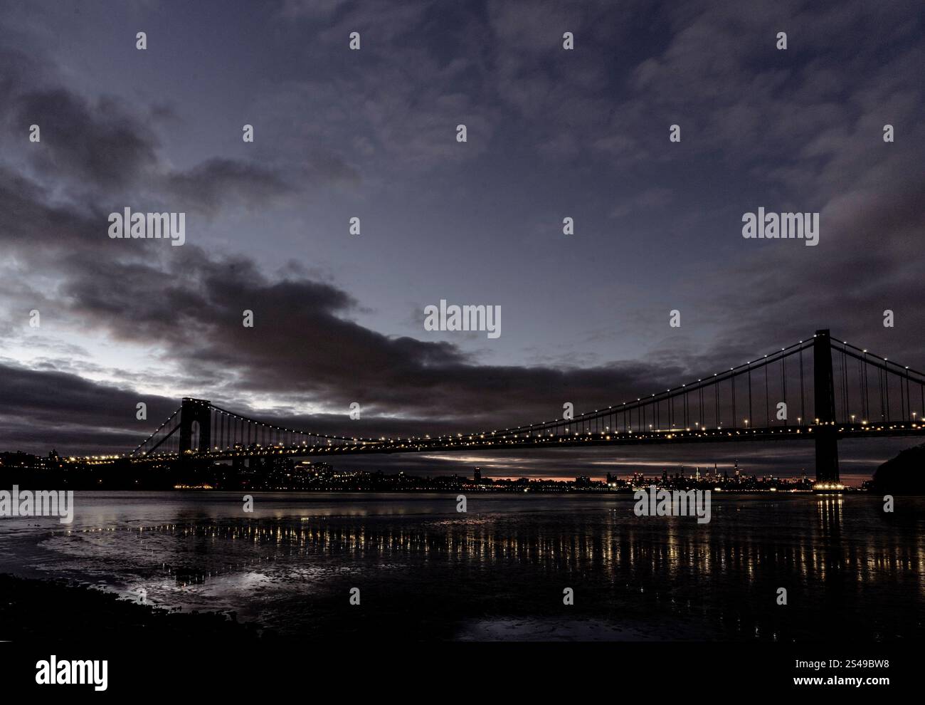 New York, NY - USA - 5. Januar 2025 Ein atemberaubender Blick bei Nacht auf die George Washington Bridge, eine Hängebrücke, mit Lichtern, die auf den Hudson R reflektieren Stockfoto