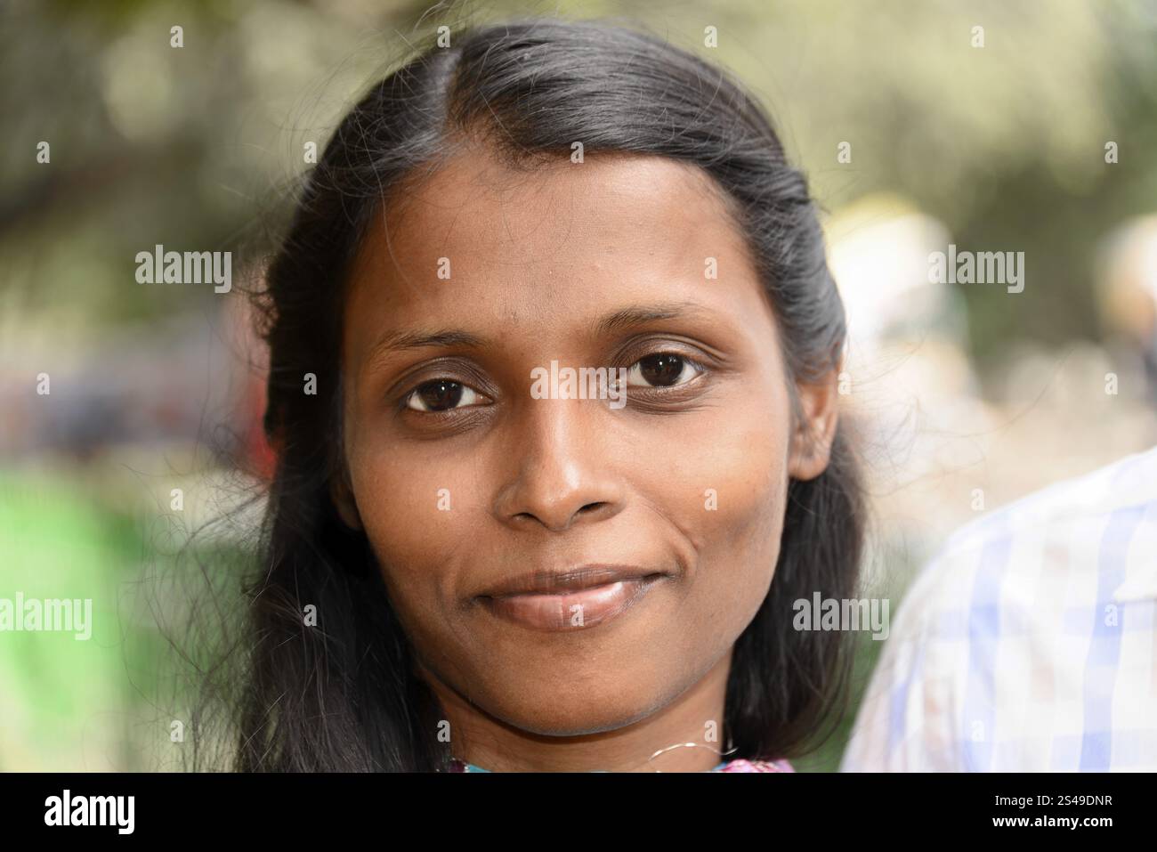 Indische Frau, Tamil Nadu, Indien, Asien, Porträt einer lächelnden Frau mit dunklem Haar vor verschwommenem Hintergrund, Mahabalipuram, Südindien, Asien Stockfoto