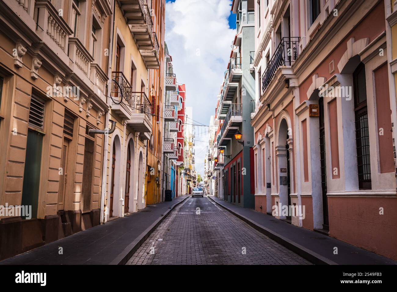 San Juan, Puerto Rico - 25. Februar 2018: Ein Auto ragt auf der schmalen, kopfsteingepflasterten, farbenfrohen Calle Tetuan in Old San Juan herunter. Stockfoto