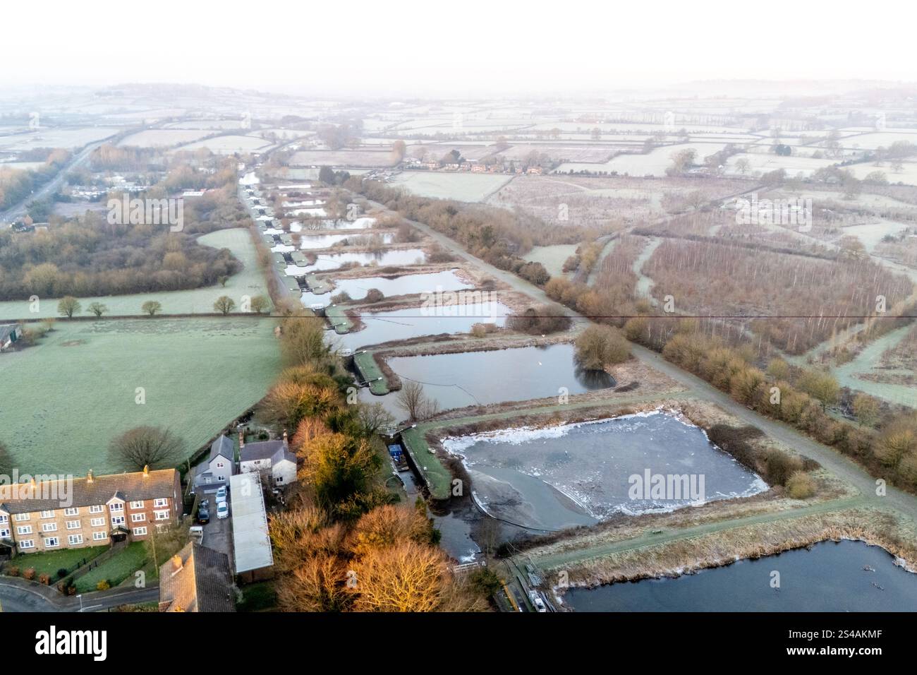 Eis bildet sich auf dem Wasser, wenn die Temperatur während des Sonnenaufgangs -4 °C (minus vier) erreicht, über den 16 Schleusen, die den steilsten Teil des Fluges bei Caen Hill Locks in Devizes, Wilsthire bilden, einer der längsten durchgehenden Schleusen des Landes. Die Caen Hill Schleusen am Kennet und Avon Canal bestehen aus insgesamt 29 Schleusen, die sich über einen Verlauf von 3 Meilen 237 m bei einer Steigung von 1 zu 44 m erheben. Bilddatum: Samstag, 11. Januar 2025. Stockfoto