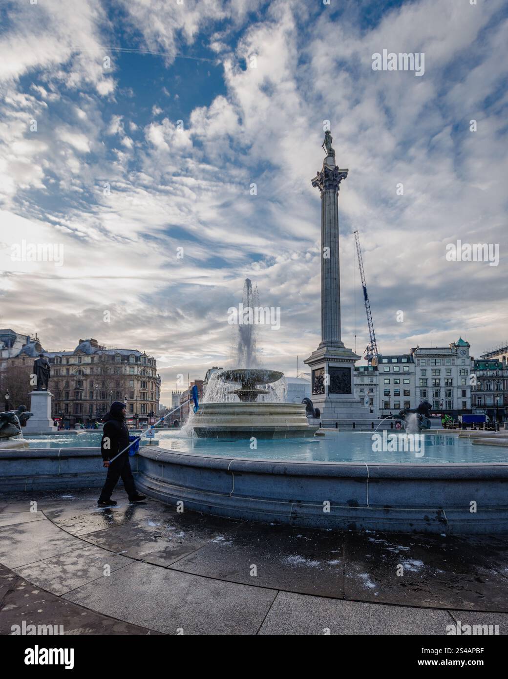 Ein Arbeiter bricht das Eis im Brunnen des Trafalgar Square während des Kaltschnapps in London. Stockfoto Ein Arbeiter bricht das Eis im Brunnen des Trafalgar Square während des Kaltschnapps in London. Stockfoto