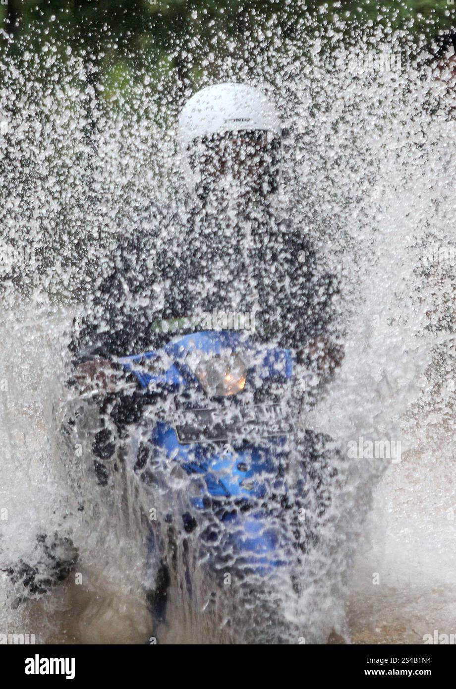 Tanjungpinang, Indonesien. Januar 2025. Ein Autofahrer weht durch Hochwasser, nachdem am 11. Januar 2025 heftiger Regen Tanjungpinang, die Hauptstadt der Provinz Riau, Indonesien, getroffen hat. Quelle: Yuli Seperi/Xinhua/Alamy Live News Stockfoto