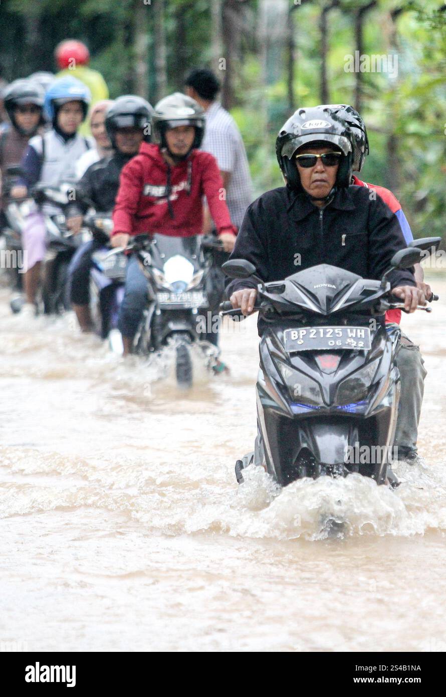 Tanjungpinang, Indonesien. Januar 2025. Autofahrer waten durch Hochwasser, nachdem am 11. Januar 2025 in Tanjungpinang, der Hauptstadt der Provinz Riau Islands, in Indonesien, heftige Regenfälle getroffen wurden. Quelle: Yuli Seperi/Xinhua/Alamy Live News Stockfoto