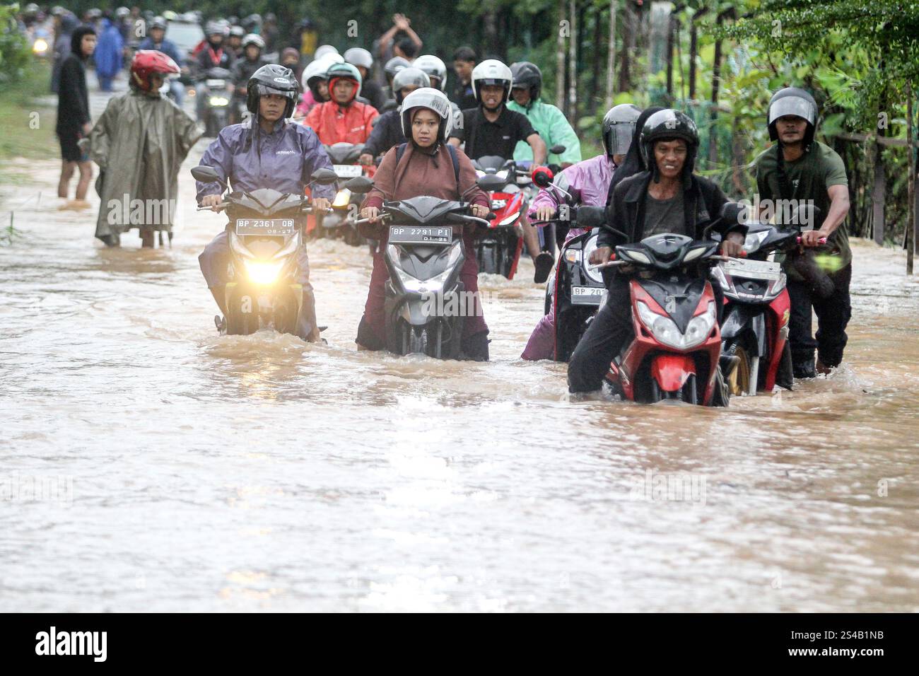 Tanjungpinang, Indonesien. Januar 2025. Autofahrer waten durch Hochwasser, nachdem am 11. Januar 2025 in Tanjungpinang, der Hauptstadt der Provinz Riau Islands, in Indonesien, heftige Regenfälle getroffen wurden. Quelle: Yuli Seperi/Xinhua/Alamy Live News Stockfoto