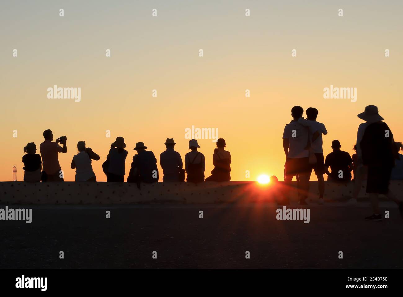 Silhouettenfiguren, abendliche Zuschauer beobachten den Sonnenuntergang in Oia, Santorin, Griechenland – 27. September 2023 Stockfoto
