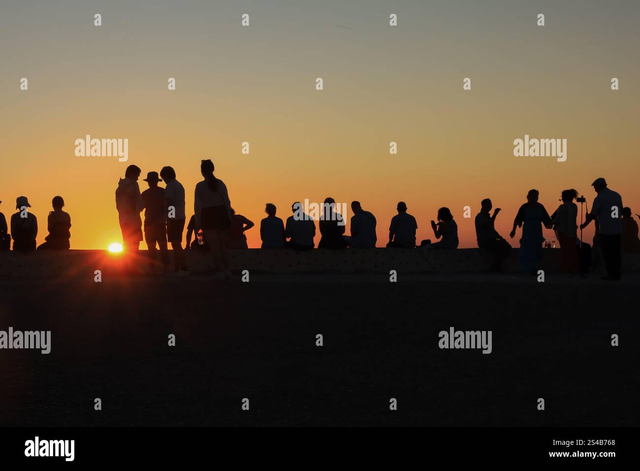 Silhouettenfiguren, abendliche Zuschauer beobachten den Sonnenuntergang in Oia, Santorin, Griechenland – 27. September 2023 Stockfoto