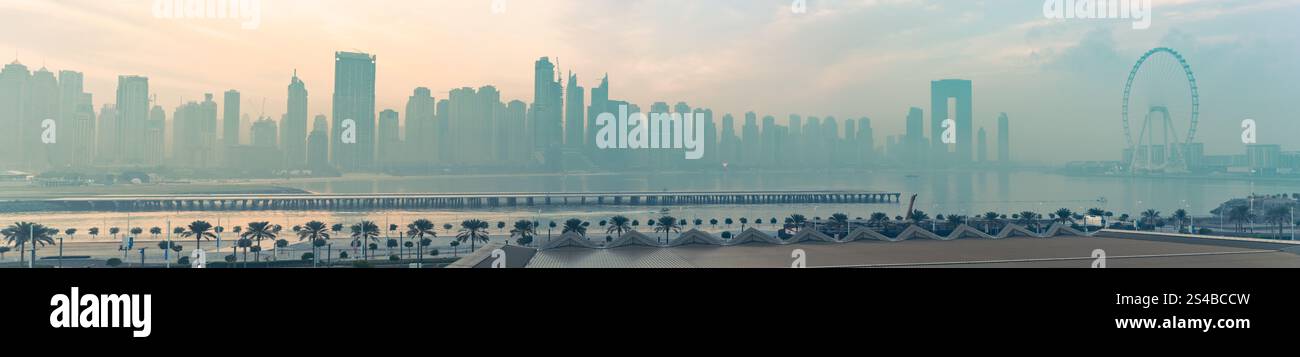 Die Sonne am frühen Morgen taucht die Skyline der Stadt in einen goldenen Farbton und schafft eine atemberaubende Silhouette aus Wolkenkratzern und dem ruhigen Wasser darunter. Diese bre Stockfoto