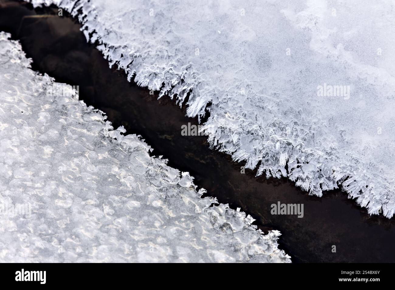 Eiskristalle, die sich im Winter entlang der Kante eines Baches bilden, North Pennines, Teesdale, County Durham, Großbritannien Stockfoto