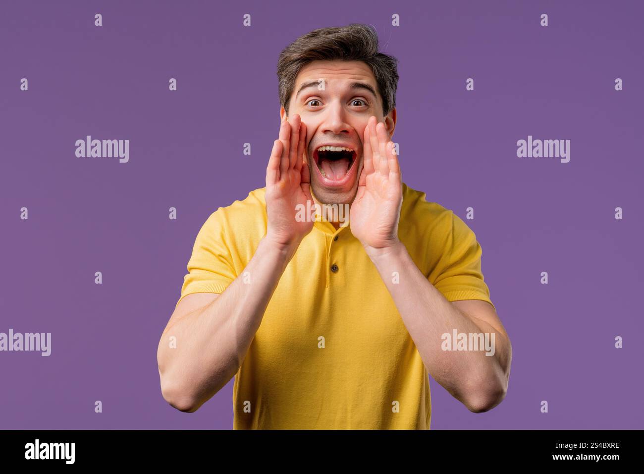 Achtung, Porträt eines gutaussehenden Mannes, der die Hand in der Nähe des offenen Mundes hält, isoliert auf violettem Hintergrund mit Kopierraum für Ihre Werbung. Hoch Stockfoto