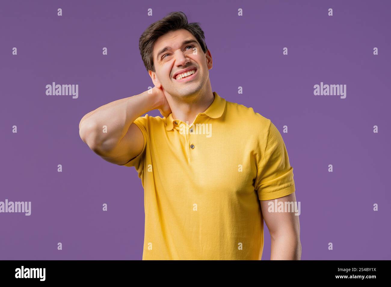 Müder junger Mann mit Schmerzen - Nackenschmerzen. Mann in lässigem Hemd macht Pause und knete mit Handmassage schmerzende Nackenmuskeln. Stockfoto
