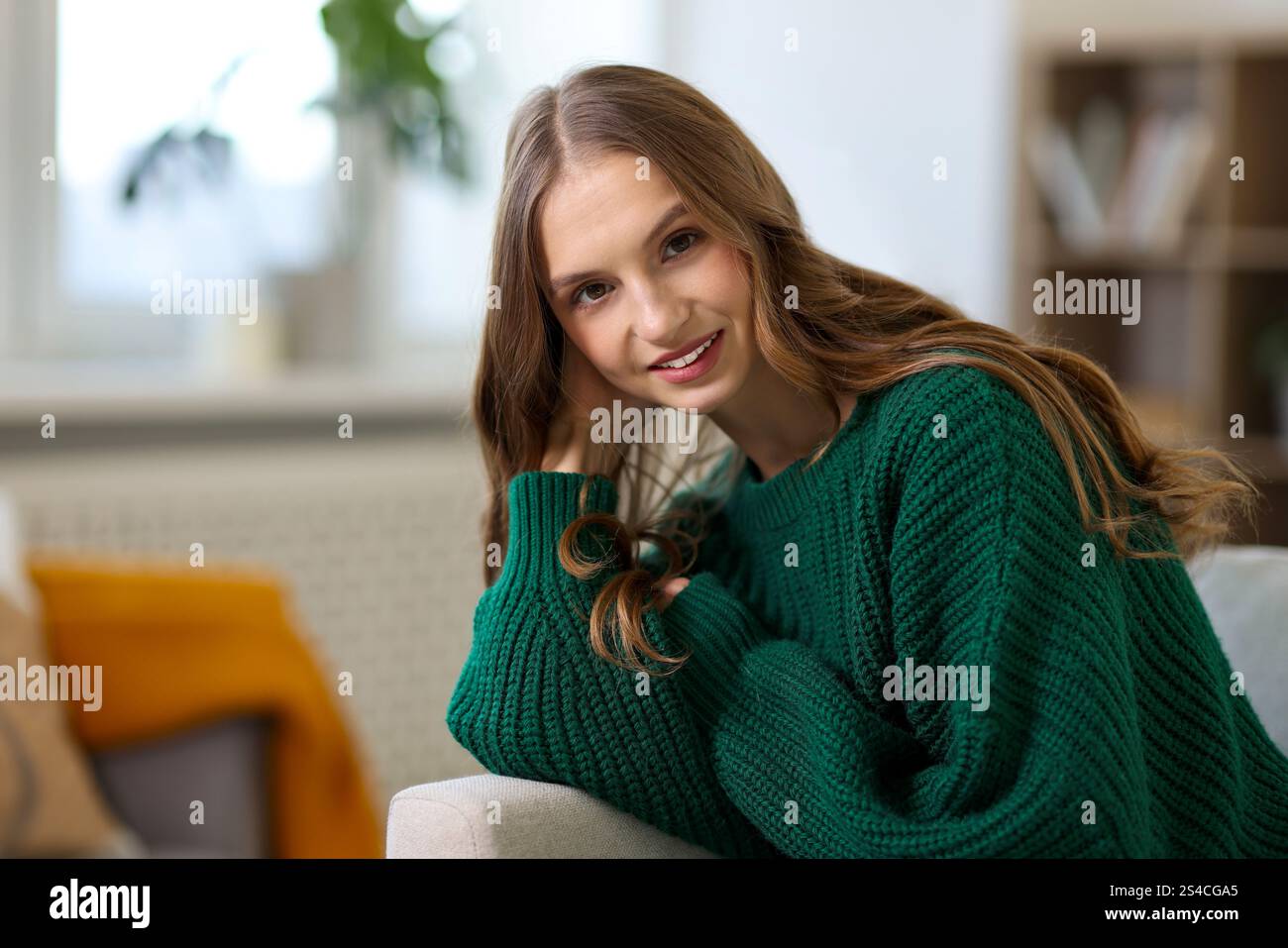 Charmante junge Frau auf Sofa zu Hause. Herbstatmosphäre Stockfoto