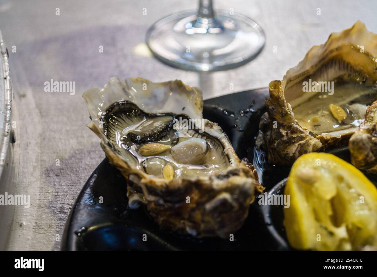 Mittagessen mit Austern, Brot, Käse und Weißwein in der Bar des Vedettes, dem überdachten Markt von Saint-Cyprien, Toulouse, Haute-Garonne, Occitanie, Frankreich Stockfoto