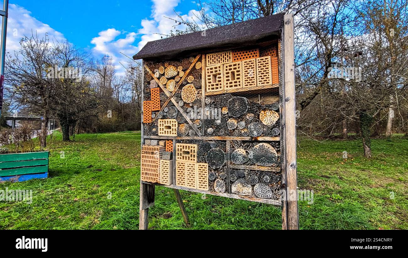 Ein Insektenhotel in einem Garten in Meersburg, Deutschland, mit Kacheldach als Regenschutz. Lebensraum für kleine Insekten Stockfoto