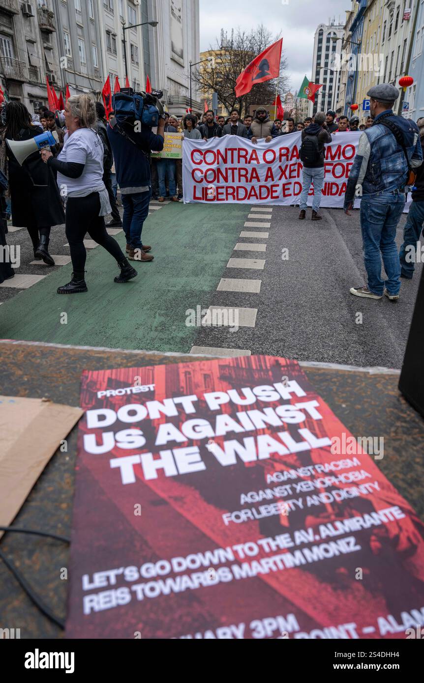 Während eines marsches wird auf dem Boden eine Plakatwand mit dem Slogan „Don't Push US against the Wall“ ausgestellt. Menschenrechtsaktivisten, soziale Gruppen und Bürger demonstrierten gegen polizeiliche Sicherheitsmaßnahmen und verteidigten die Werte der Solidarität und Brüderlichkeit gegenüber Einwanderern. Die Menschen versammelten sich auf dem Alameda-Platz und marschierten zum Martim-Moniz-Platz in der portugiesischen Hauptstadt. Diese Veranstaltung ist eine Reaktion auf die jüngsten Polizeieinsätze im Zentrum von Lissabon, die Debatten über die öffentliche Sicherheit und die Bürgerrechte ausgelöst haben. Stockfoto