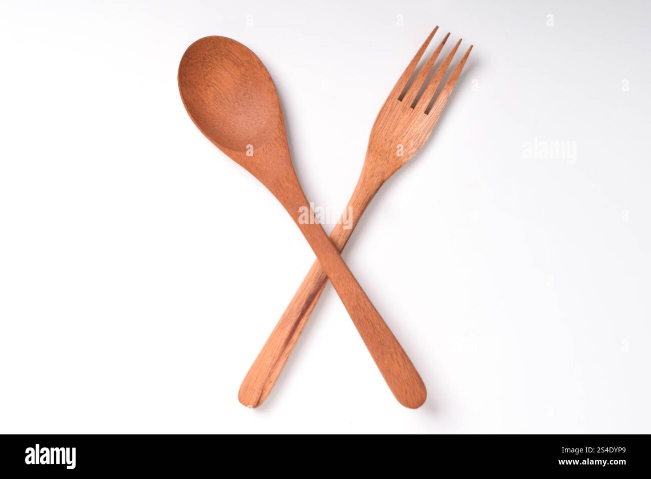 Holzlöffel und Gabel, als Straßenschild überquert, isoliert auf weißem Hintergrund. Haushaltswaren Stockfoto