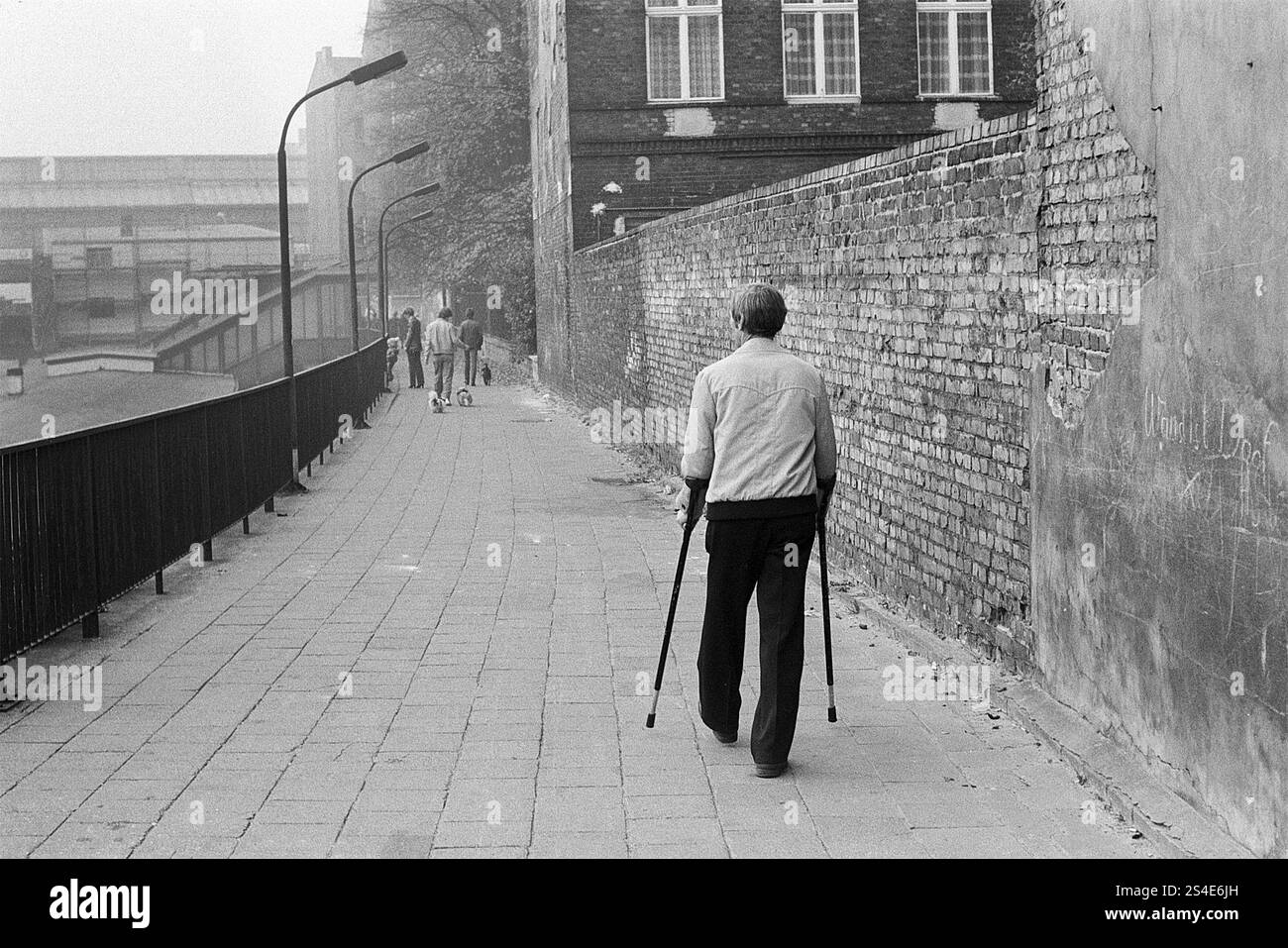 10.10.1983 DDR Ost-Berlin, Prenzlauer Berg, Mann mit Krücken zu Fuß zum S-Bahnhof Schönauser Allee, Ost-Berlin, Berlin-Prenzlauer Berg, DDR Stockfoto