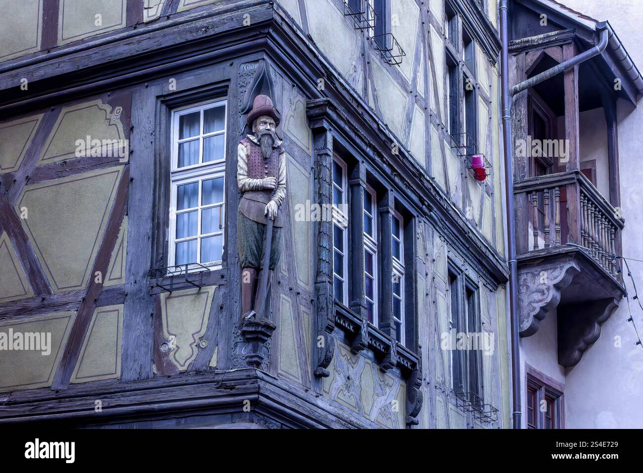 Detail des berühmten historischen Fachwerkgebäudes aus dem Jahr 1537 Haus Pfister mit einer geschnitzten Skulptur eines mittelalterlichen Mannes an der Ecke o Stockfoto