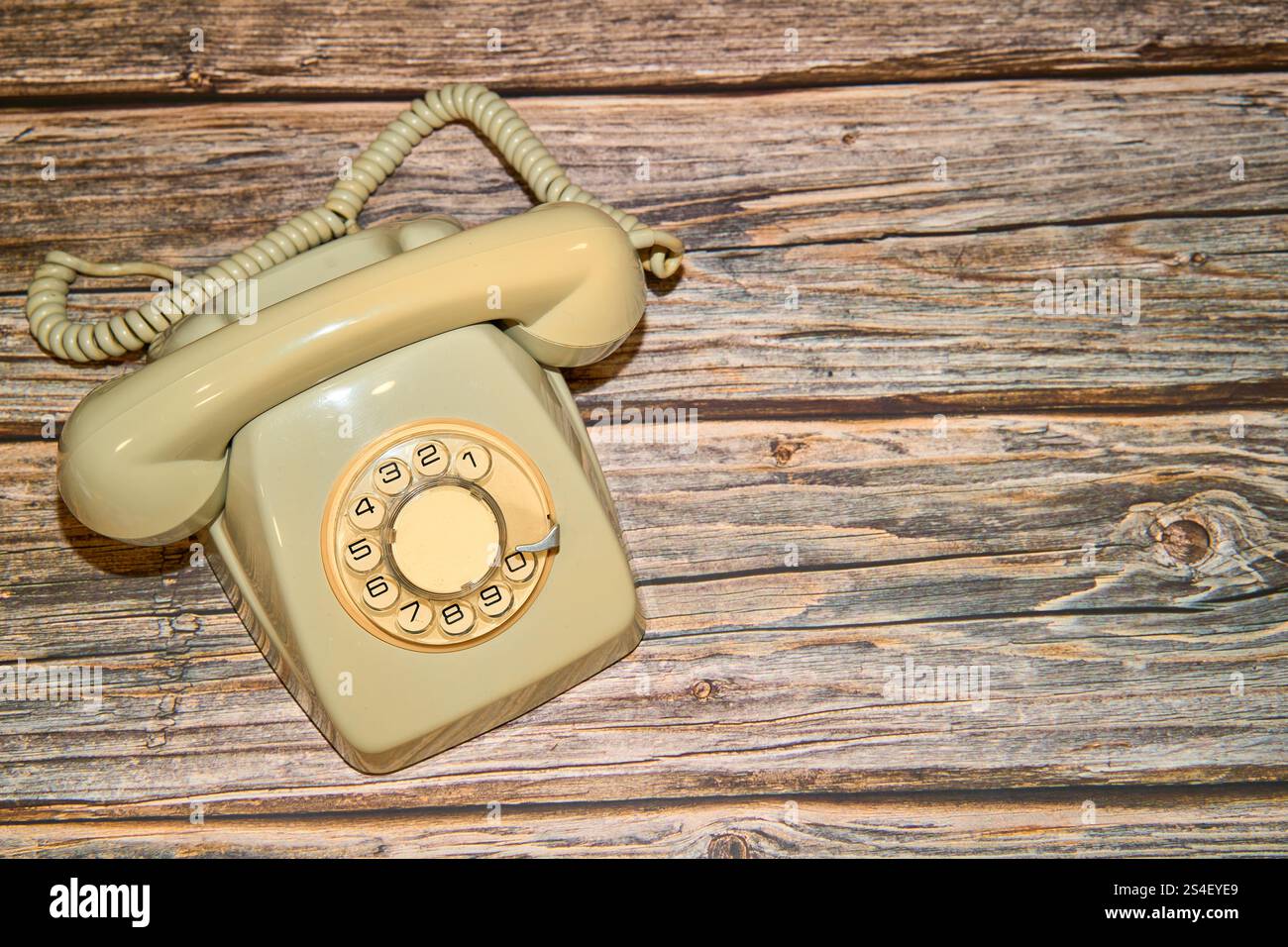 Abgenutztes Retro-Telefon auf einem Holztisch Stockfoto