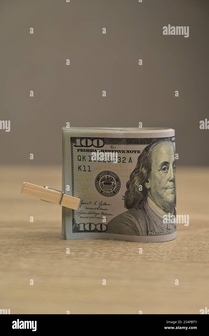 Rolle von 100 US-Dollar-Geldscheinen aus Papier mit einer kleinen Kleiderschachtel auf einem hölzernen Tischhintergrund, isoliert Stockfoto Rolle von 100 US-Dollar-Geldscheinen aus Papier mit einer kleinen Kleiderschachtel auf einem hölzernen Tischhintergrund, isoliert Stockfoto